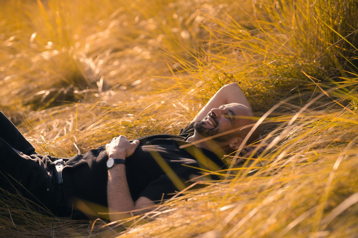A photo of a happy man resting outdoors in the sun