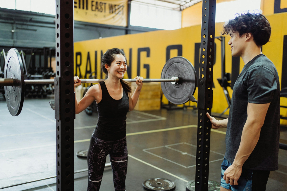 Woman Looking at a Man while Weightlifting