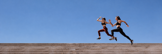Two fit women jumping over stairs